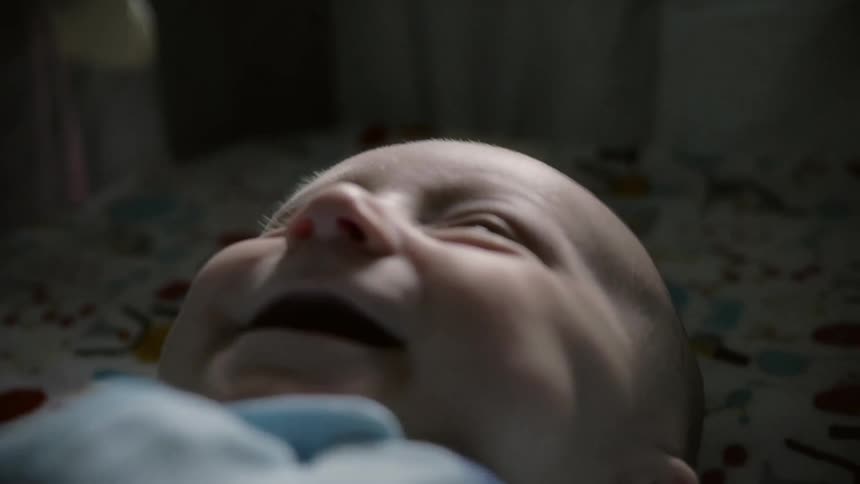 A baby laughs while laying down