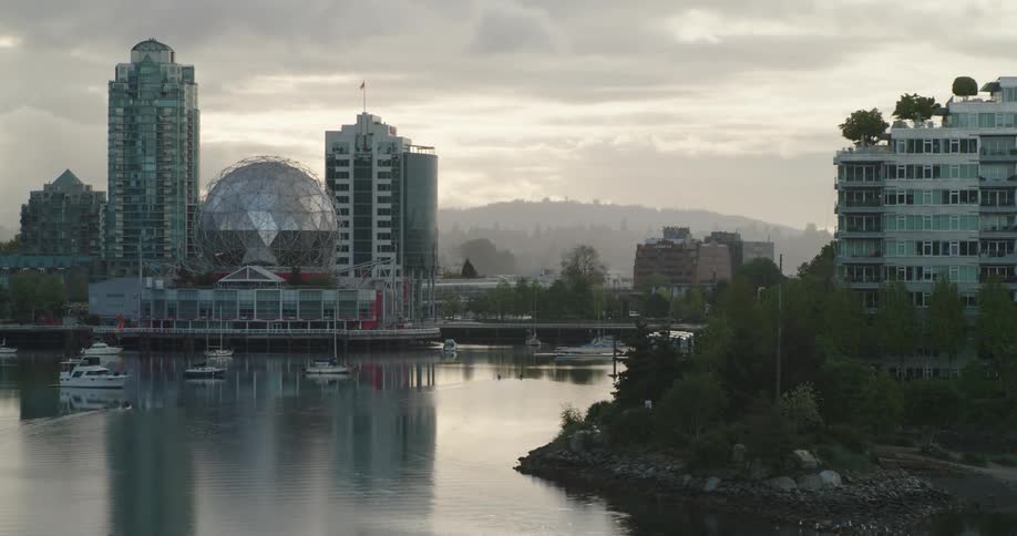 Timelapse of paddle-boards moving through calm water by the city