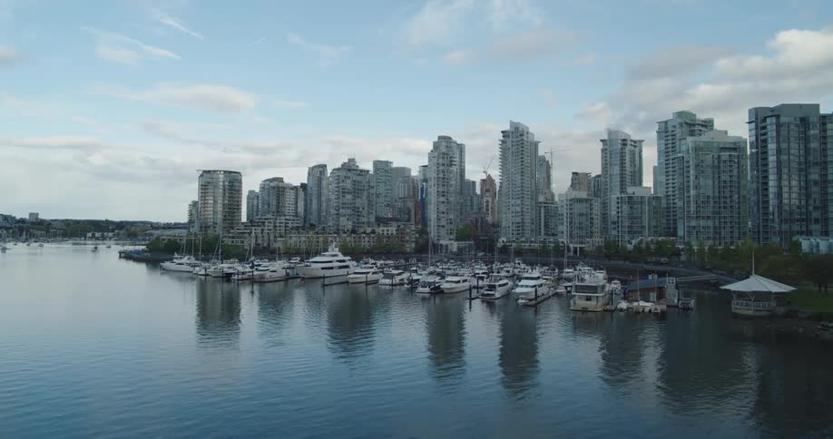 The boats are docked by the city harbor at dawn