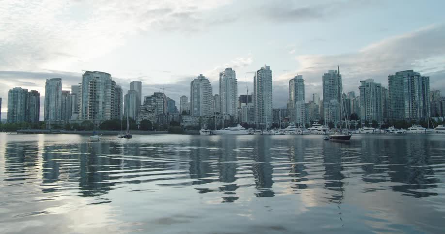 Apartment towers are reflected in Vancouver's False Creek at sundown