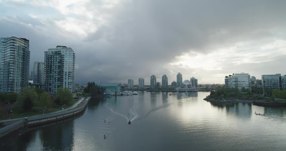 An elevated view of high rise buildings on the shore and boats sailing in the waterway