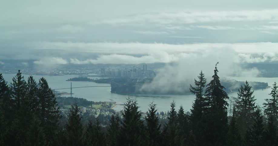 The clouds drift aside to reveal downtown Vancouver on a foggy day