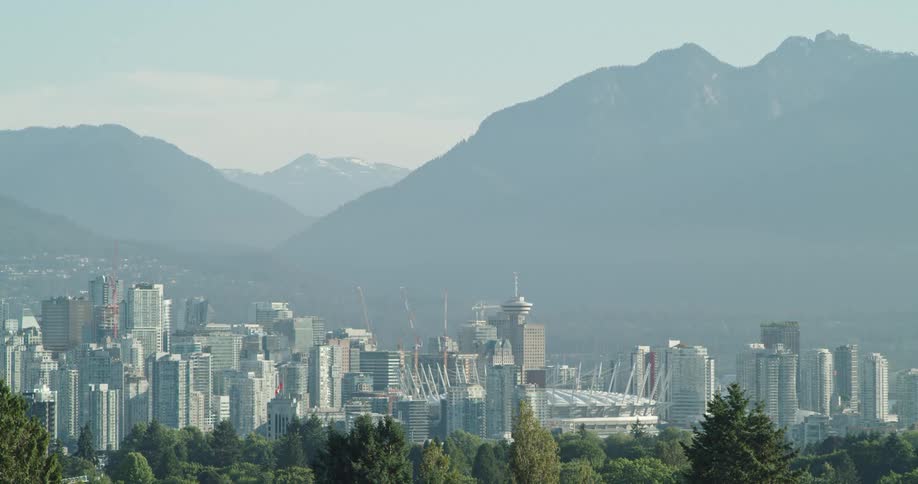 City skyline shown on a clear morning with towering mountains in background