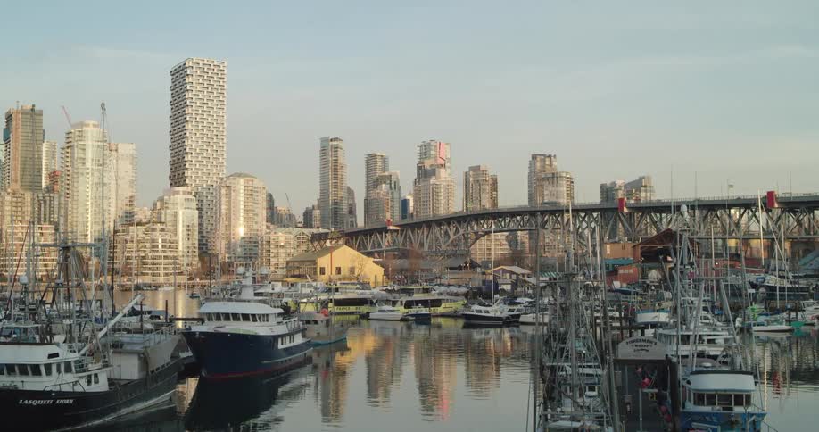 Boats fill a marina below a bridge downtown