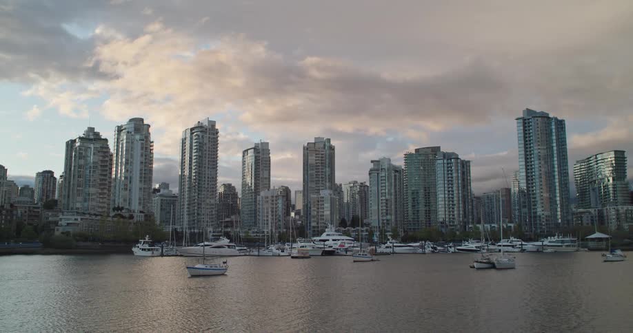 Boats are docked along side Vancouver's False Creek area with skyscrapers