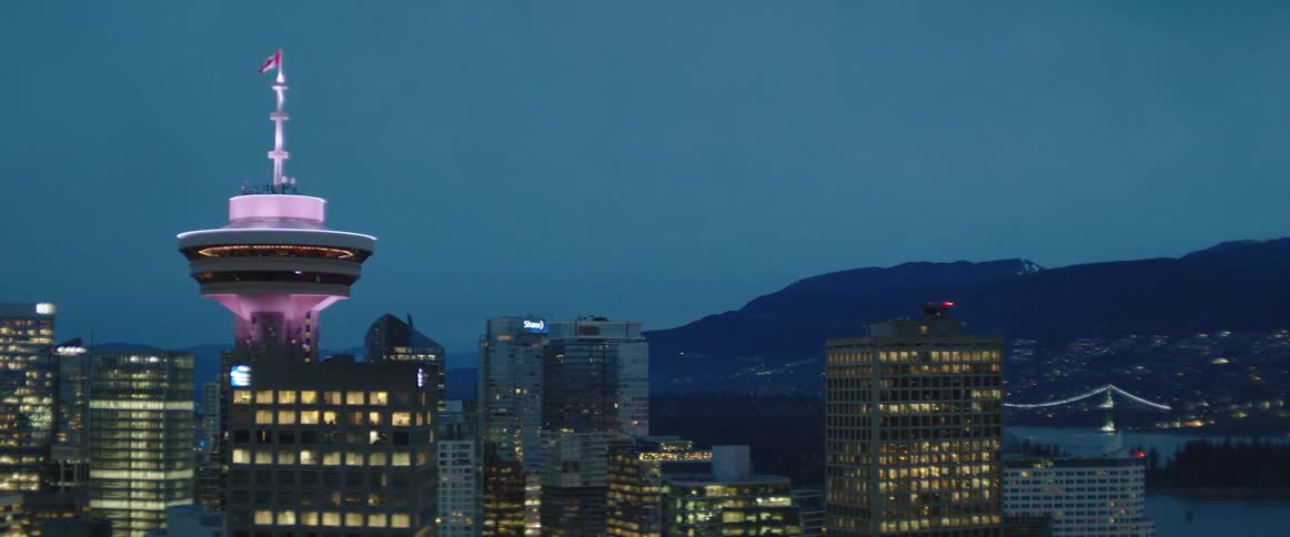 The Canadian flag flies above Harbour Centre tower in downtown Vancouver at night