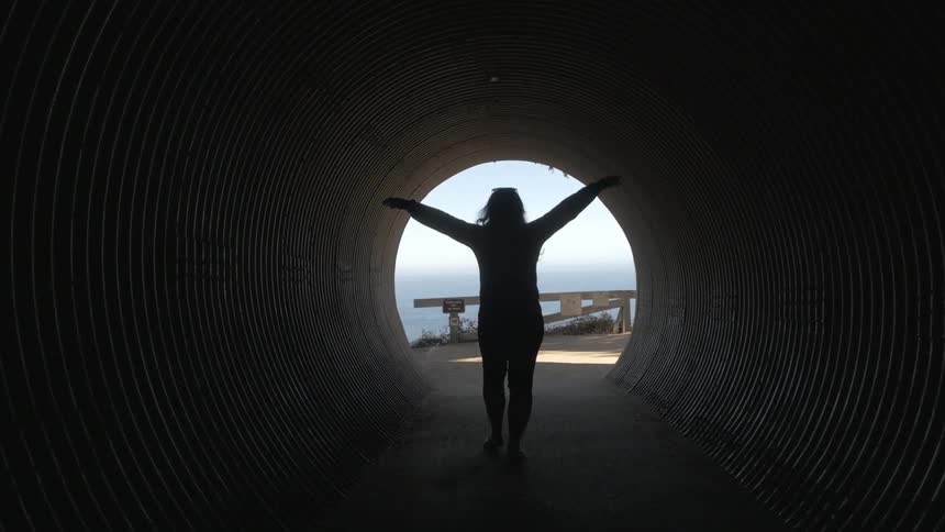 A person is walking in a dark tunnel