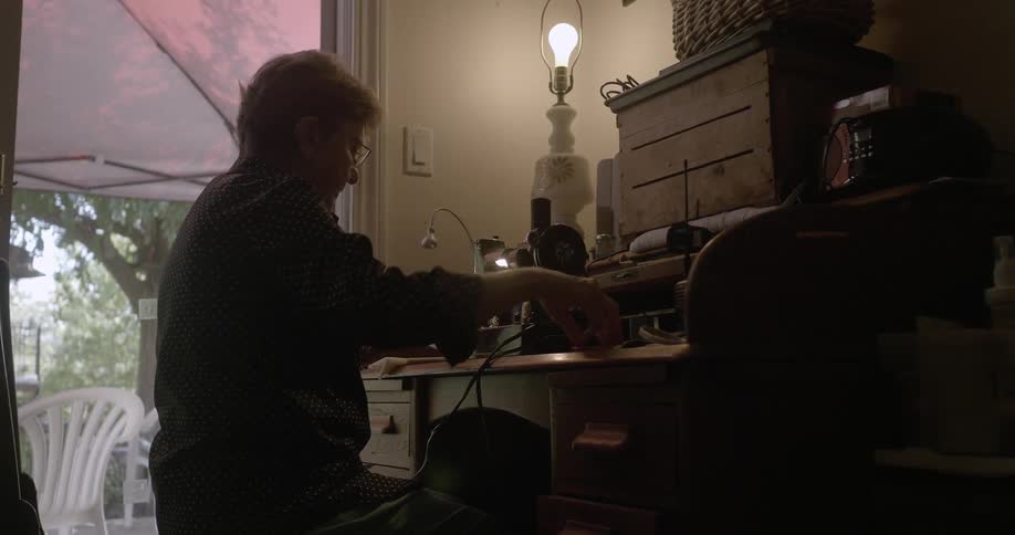 A woman is setting up to use a sewing machine