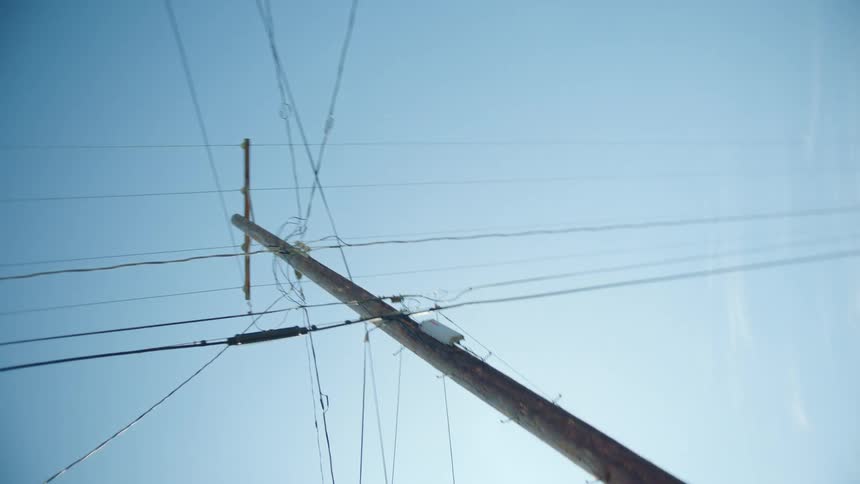A utility pole next to a building under a clear sky