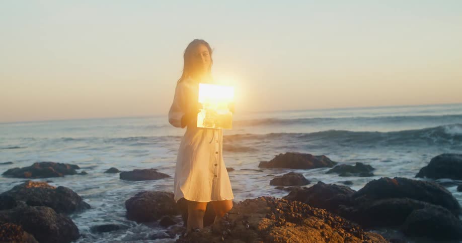 A poses stands in knee high ocean water posing with a picture