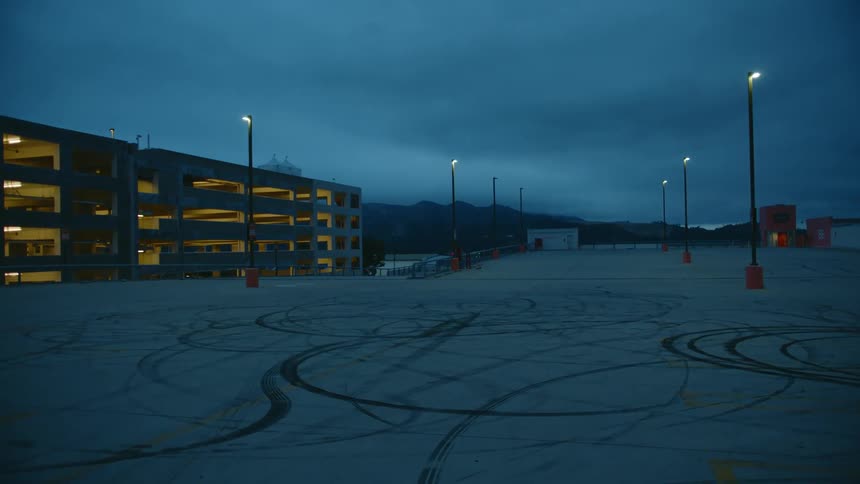 A parking lot and parking garage sit empty at night