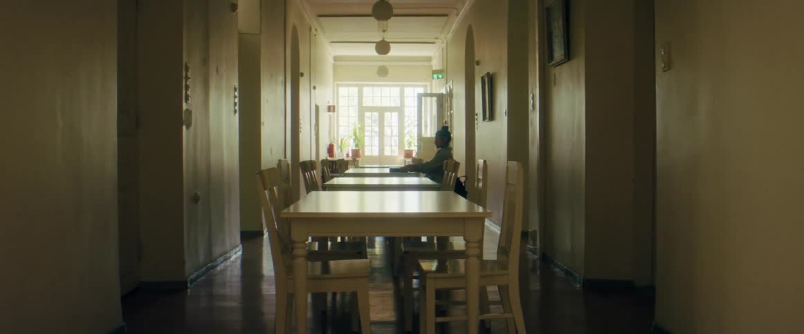 A female sits at a table in a restaurant and reads a book