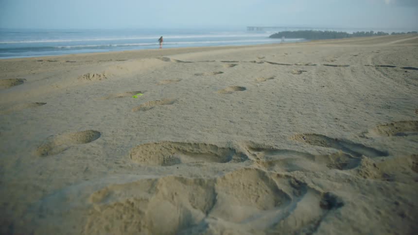 A person running on the beach in the middle of the day
