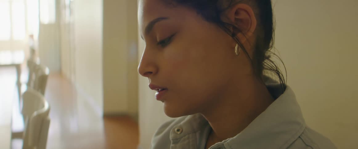 Woman finishes writing then sits back sighing