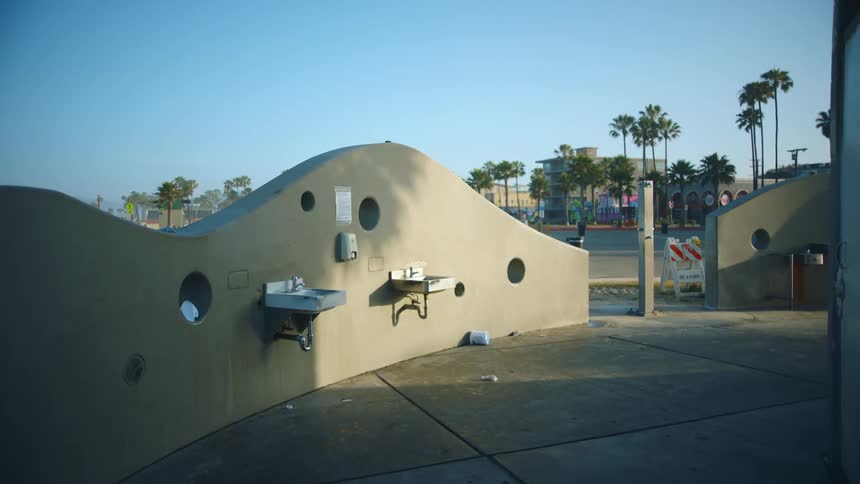 A safety sign sits in the entrance to an outdoor bathroom at an empty park
