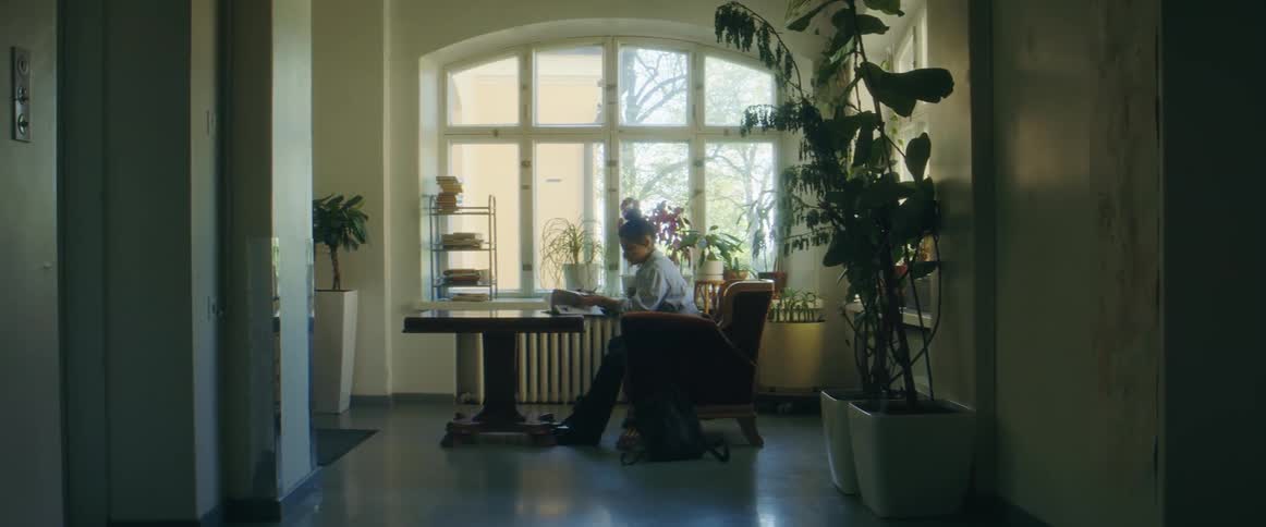 A woman sitting at a table reading and writing