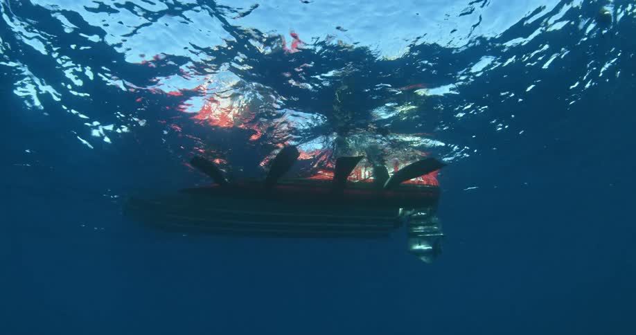 Peoples feet are in the water sitting on a raft above