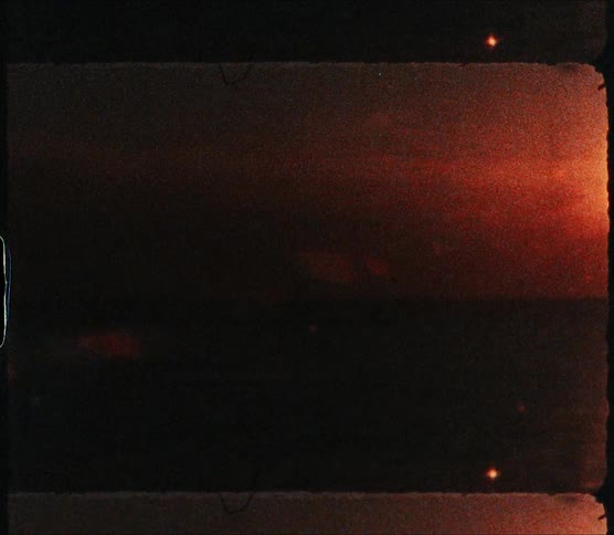 Sun glares from red sky reflecting off rippling ocean water