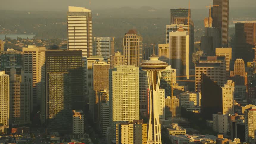 Smog haze covers buildings surrounding space needle with water dividing city downtown from remaining city