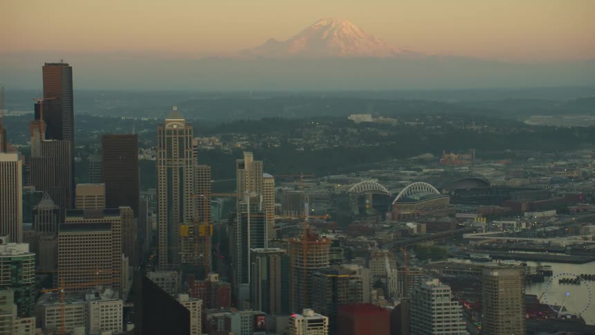 The skyline of a metropolis with a foggy mountain looming on the horizon