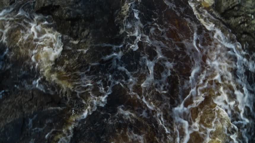 Water rippling and flowing in a river with rocks