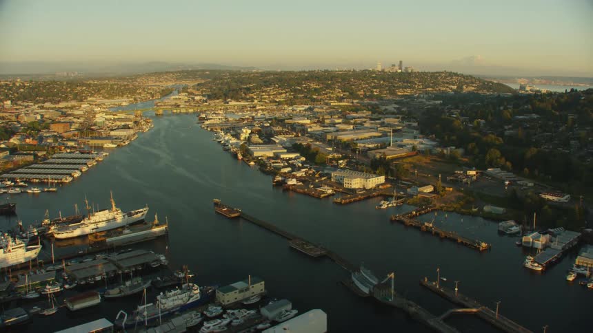 Boats and shipped docked along the city waterfront with skyscrapers on the horizon on a hazy day