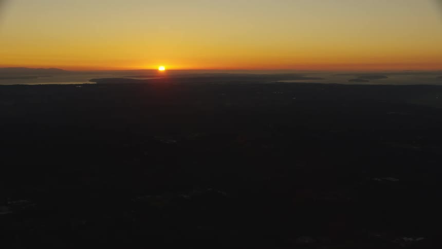 The sun sets over the lake near the city