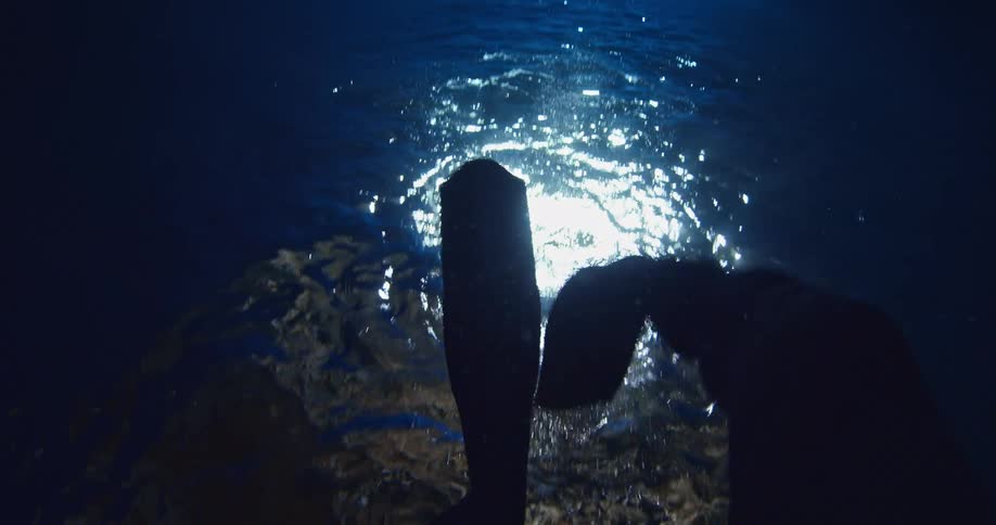 A person's scuba flippers are moving in the water