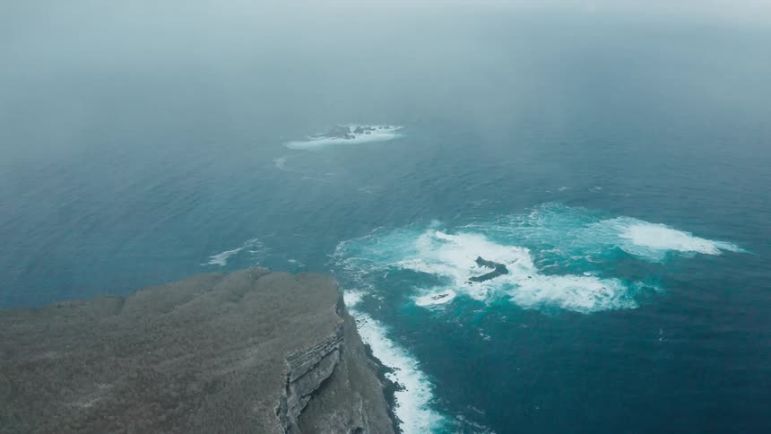 Aerial view of a promontory on the ocean under the clouds