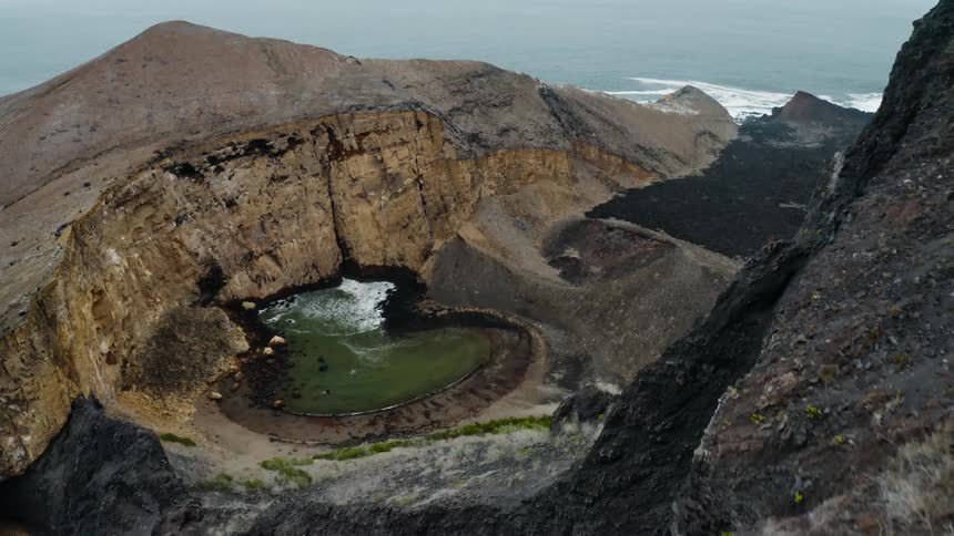 A circular spring sits at the base of a vast canyon