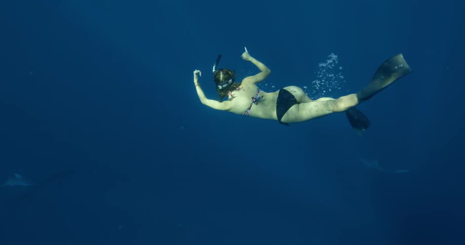 A woman swims in the water with a snorkel