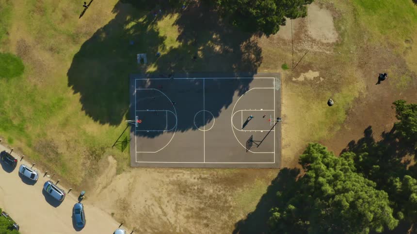 An aerial view of people playing basketball outside