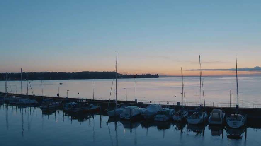 A marina with boats with land the sky and clouds in the background