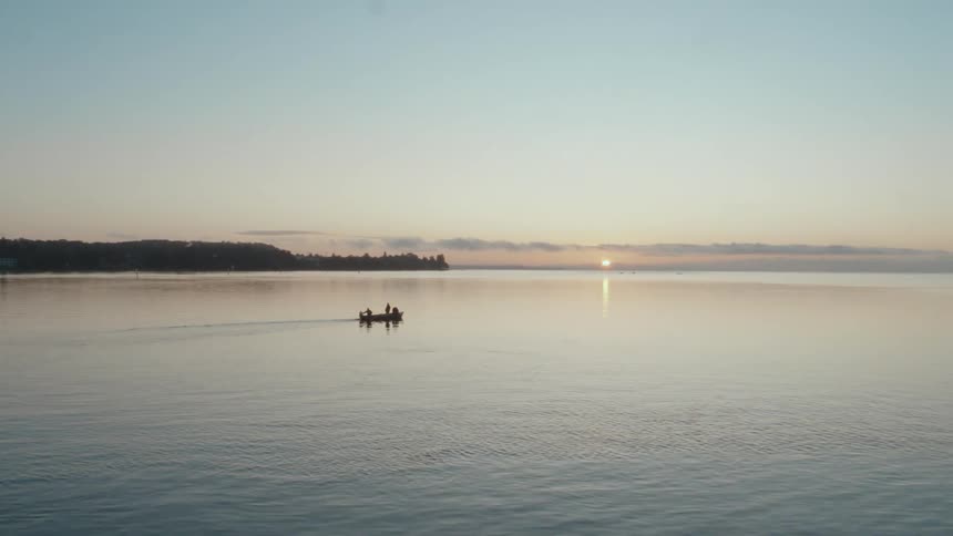 Three people on a boat just off the dock