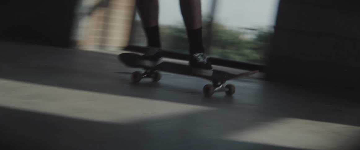 A person skateboarding in a corridor in a building