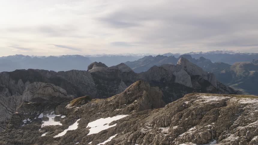 Snow sits on the mountains under a cloudy sky