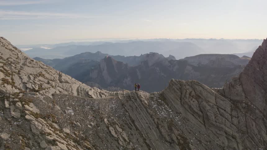 Two people are standing on top of the mountain