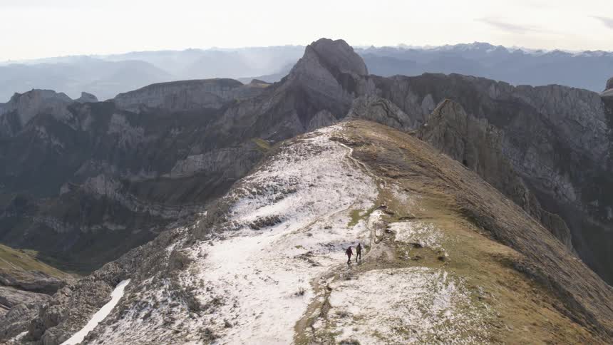 Two people hiking up in a mountain range