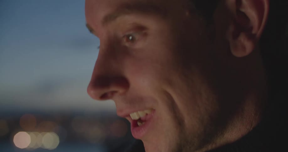 A man smiles as he talks and communicates with another person
