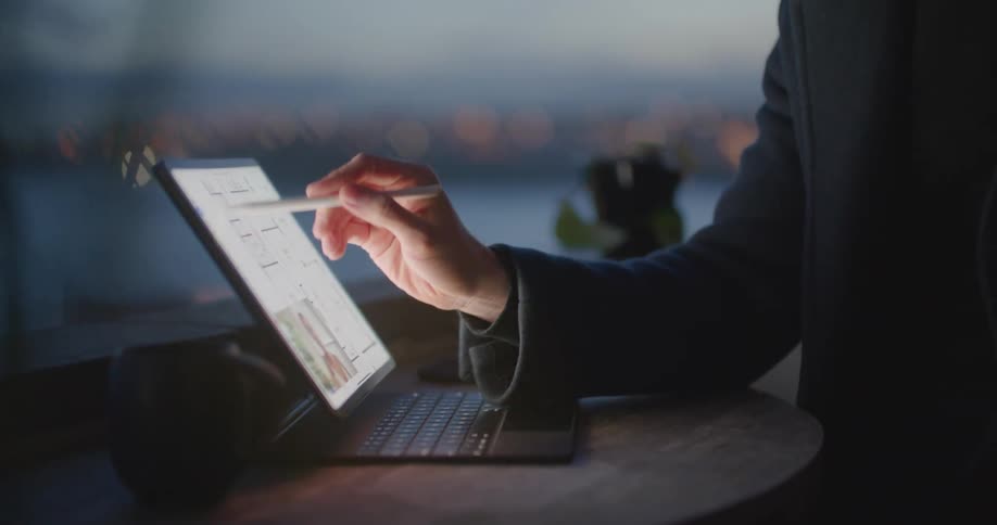 A man draws on a tablet with a pen and appears to be talking as well