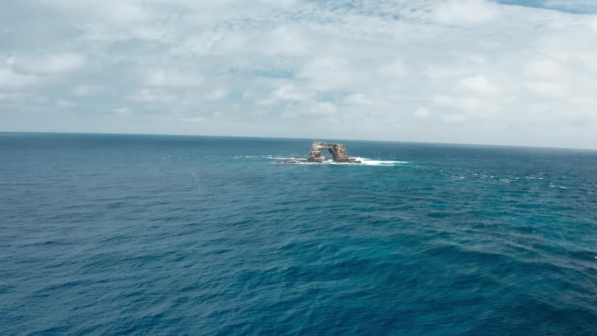 An aerial view of a large rock in the ocean