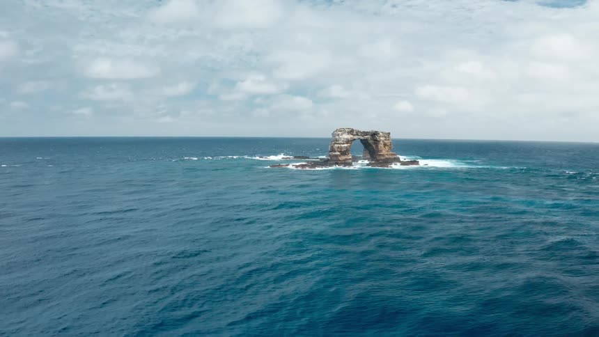 Aerial view of ocean water is displayed near an island
