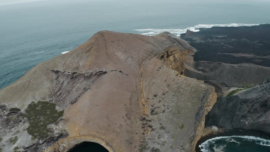 Arch allows sea to enter cave as another tunnel allows water to flow into small pond