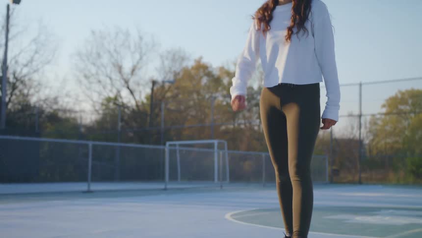 A woman is kicking the soccer ball