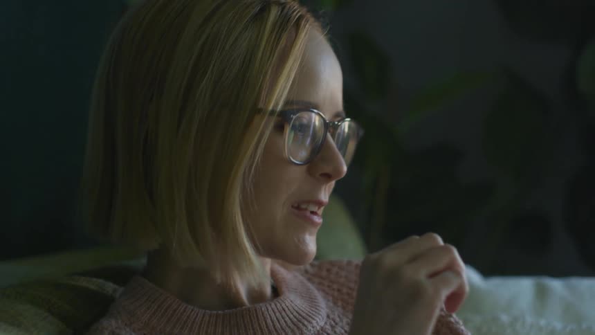 A woman makes large gestures with her hand as she talks to someone else