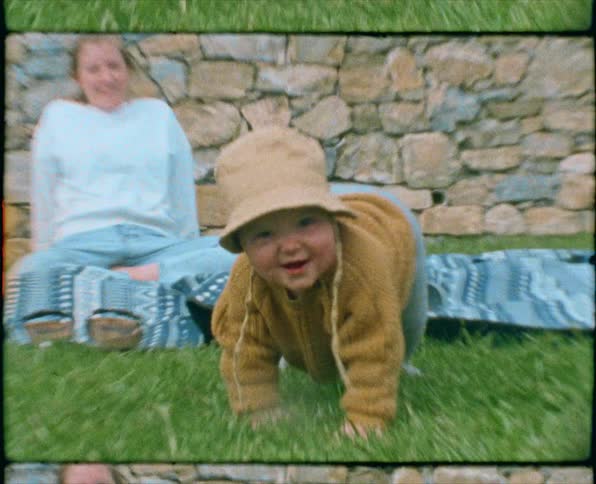 A baby crawls in the grass