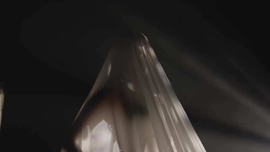 Silhouette of a woman covered in a veil inside a dimly lit room