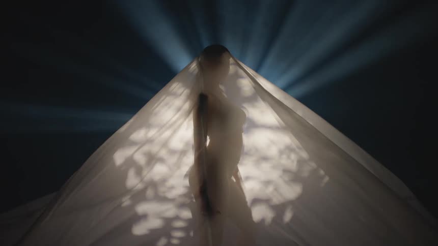 A woman in a room with a sheet over her