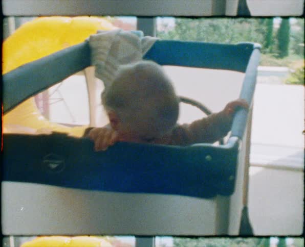 A mother sits on the bed as the baby plays