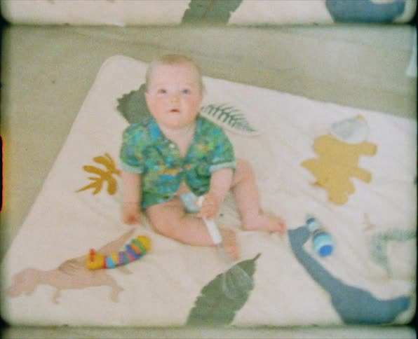 A baby smiling and banging a whisk